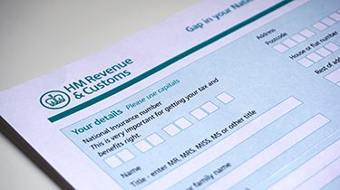 Photo of filling in a HM customs form a personal details for UK self assessment tax and benefits right.